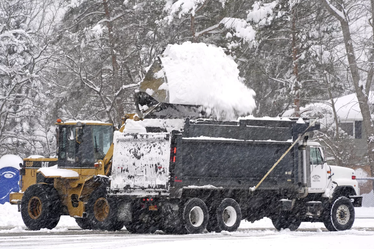Snow is cleared from a Highmark Stadium parking lot for a Sunday Night Football game between the Buffalo Bills and the San Francisco 49ers on Sunday in Orchard Park, N.Y.