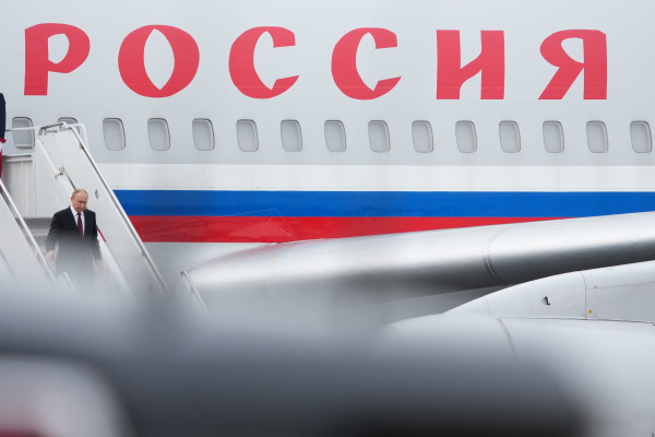 Russian President Vladimir Putin walks down steps as he exits his airplane upon arriving at Joint Base Elmendorf-Richardson.