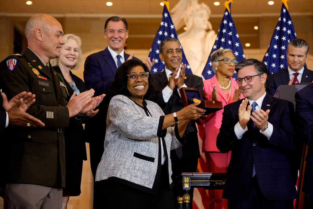 House Speaker Mike Johnson, R-La., presents Debra Willett, the granddaughter of Harlem Hellfighter Sgt. Leander Willett, with the Congressional Gold Medal on behalf of all of the "Harlem Hellfighters" of World War I during a ceremony on Capitol Hill on Wednesday in Washington, D.C.