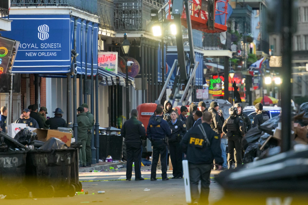 FBI investigators arrive at the scene where the white Ford F-150 pickup truck that crashed into a work lift after allegedly driving into a crowd of New Year's revelers in the French Quarter of New Orleans.