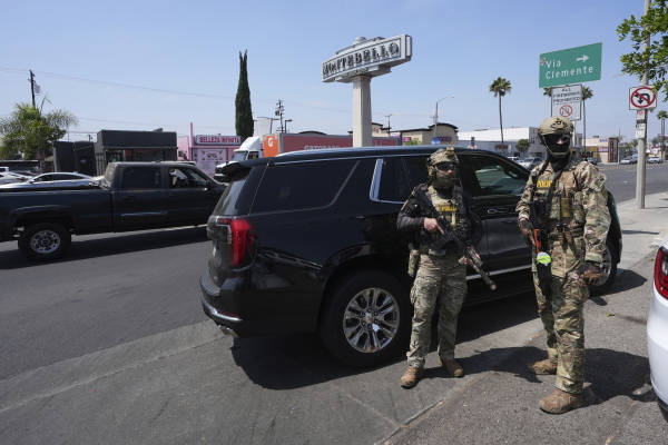 Immigration agents conduct an operation at a car wash on Friday, Aug. 15, 2025, in Montebello, Calif.