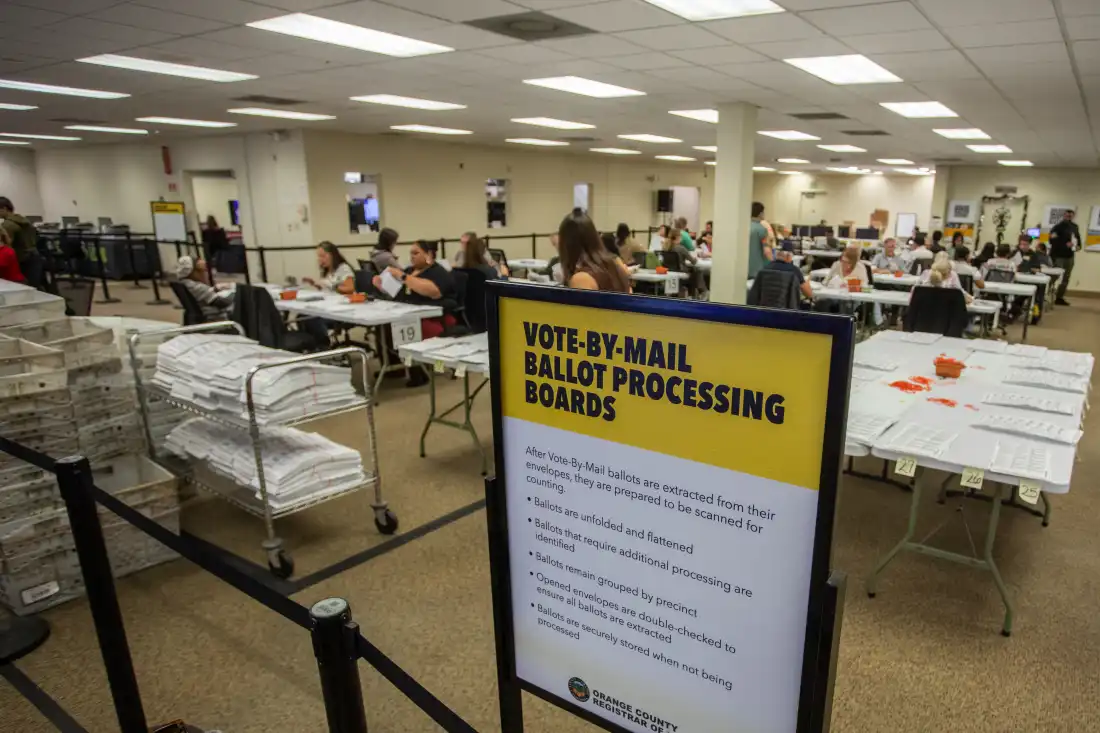 People extract ballots from their envelopes and prepare them to be scanned for counting in the Vote-By-Mail Processing Boards area at the Orange County Registrar of Voters Facility in Santa Ana, Calif. on Oct. 28, 2026.