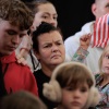 Newly arrived South Africans listen to officials from the Department of Homeland Security and the State Department make welcome remarks at the Atlantic Aviation Dulles hangar near Washington Dulles International Airport on May 12, 2025 in Dulles, Virginia.