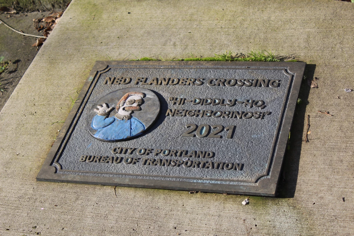 A plaque on the sidewalk at one end of Ned Flanders Crossing in Portland (renamed by the local Bureau of Transportation from Flanders Crossing in 2021) shows how proud the city is of its connection to The Simpsons.