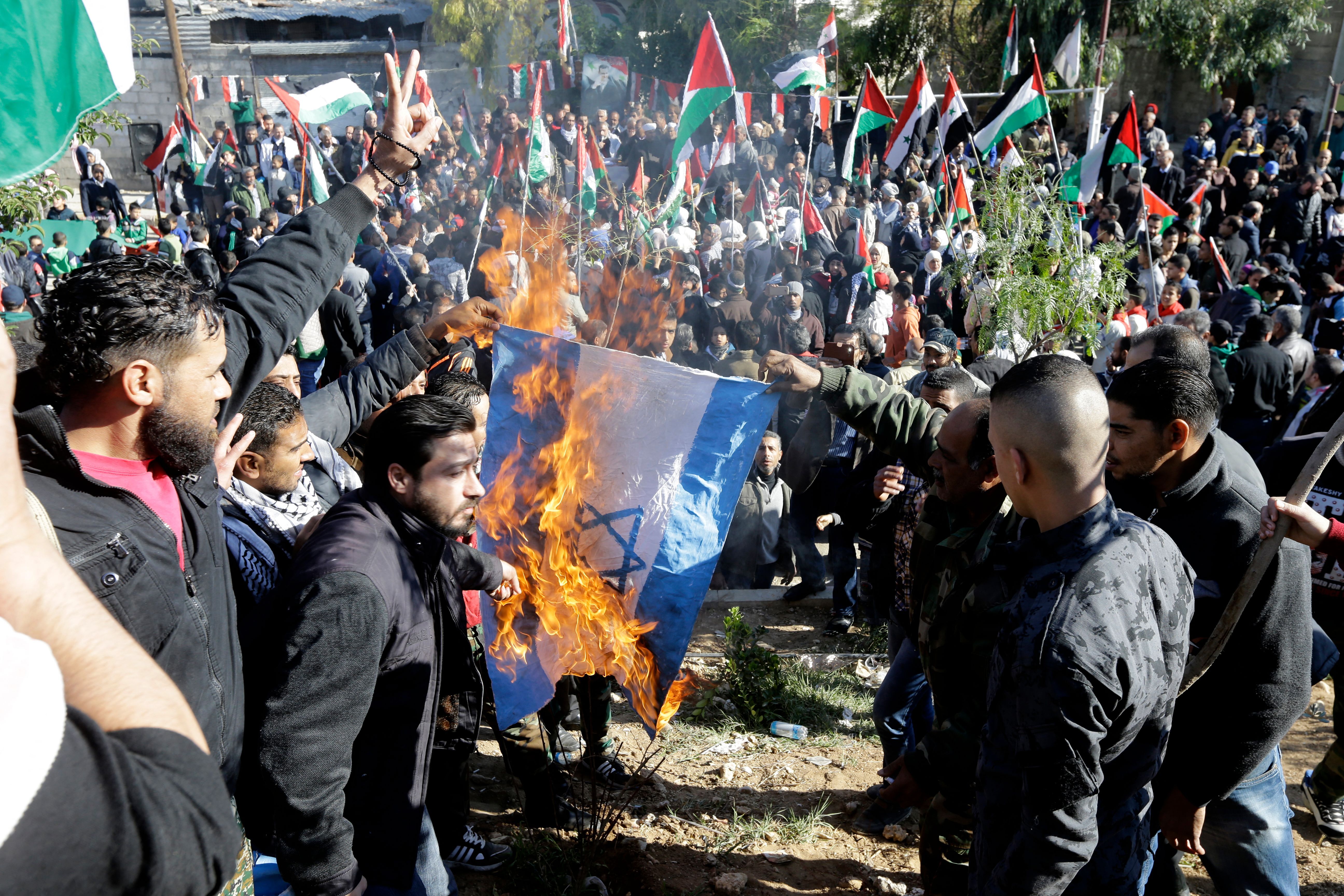 Palestinian refugees burn an Israeli flag during a demonstration at the Jaramana Camp on the edge of Damascus, Syria, in 2017. At that time, they were protesting President Trump