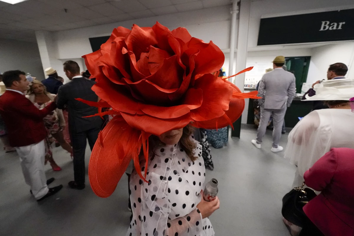 Brittany McKewn, of Asheville, N.C., wears a hat shaped like a rose before the 148th running of the Kentucky Derby horse race at Churchill Downs Saturday, May 7, 2022, in Louisville, Ky.