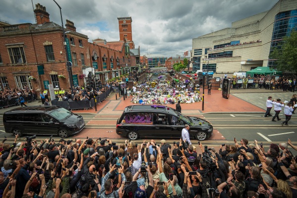 Ozzy Osbourne's funeral cortege makes it way through the streets of Birmingham, England, past the Black Sabbath Bench on Wednesday. The Black Sabbath frontman passed away on July 22, at age of 76.