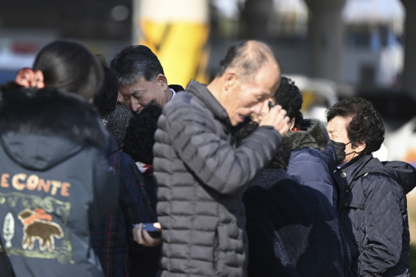 Family members of the passengers on a plane which burst into flames, weep at the Muan International Airport in Muan, South Korea, on Sunday.