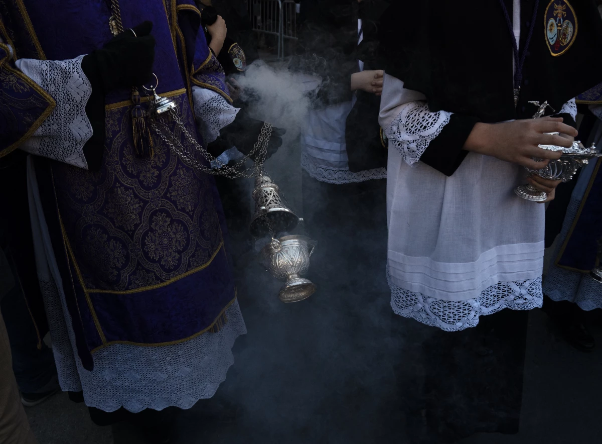 Penitents of the Los Estudiantes brotherhood take part in a procession during Holy Week in Seville, Spain, on March 31.
