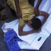 A Palestinian boy mourns over the body of his 12-year-old friend, Abdullah Ahmed, who was killed in an Israeli strike that targeted a drinking water distribution point, at Al-Awda Hospital in Nuseirat, central Gaza Strip, Sunday, July 13, 2025.