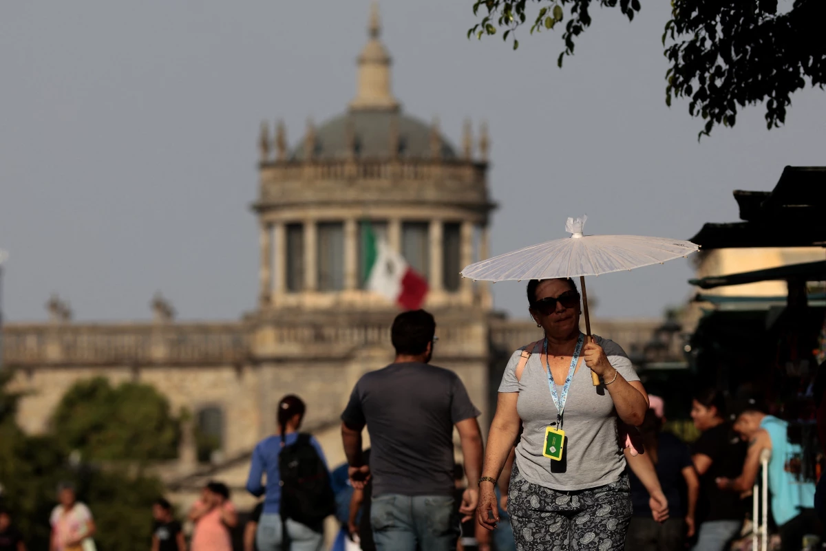 People protect themselves from the sun during a heat wave in Guadalajara, Mexico, in 2024. Temperatures topped 110 degrees Fahrenheit across many parts of the country during the heat wave. A new study finds that young people are disproportionately at risk from extreme heat in the country.