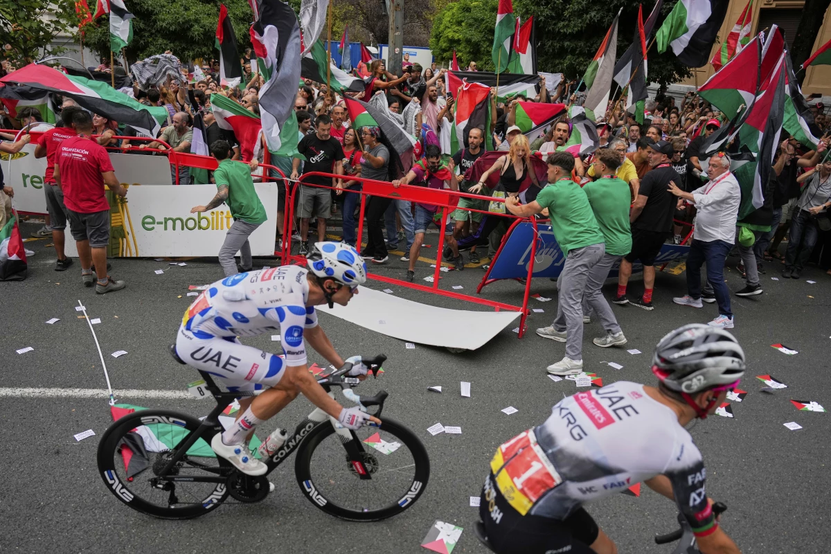 People hold Palestinian flags as they try to disrupt the eleventh stage of the Spanish Vuelta cycling race, from Bilbao to Bilbao, Spain, Wednesday, Sept. 3, 2025.