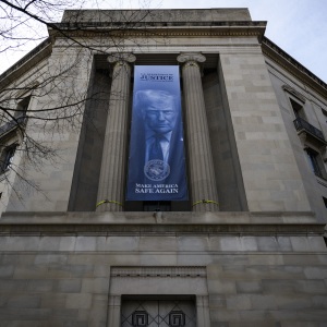 A banner of an image of President Trump is displayed on the facade of the U.S. Department of Justice headquarters in Washington, D.C., in February 2026.