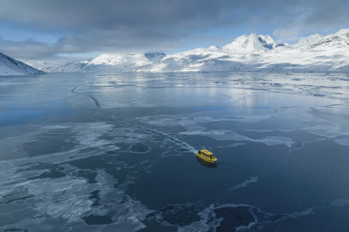 A boat rides through a frozen sea inlet outside of Nuuk, Greenland on March 6.