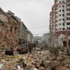 People walk near apartment buildings damaged after a Russian attack in Kyiv on Sunday.
