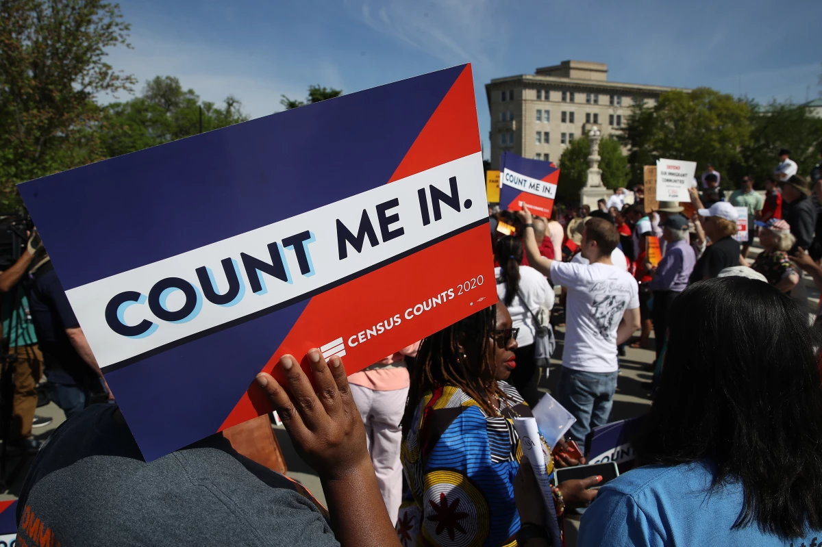 Protesters hold signs saying 'COUNT ME IN' at a 2019 rally against the Trump administration's push for a census citizenship question outside the U.S. Supreme Court in Washington, D.C.