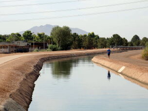 A man runs along the Eastern Canal in Gilbert, Arizona on August 26, 2026. The canal carries water from the Salt River Project. Those supplies are a major part of cities' response to smaller allocations from the Colorado River.