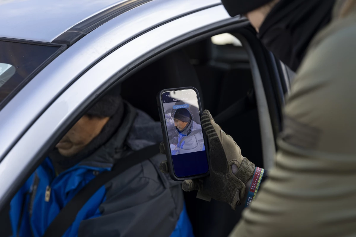 Border Patrol Agent scans the face of a driver as they stop and question him in the street during an Immigration Enforcement Operation in Minneapolis on Jan. 13.