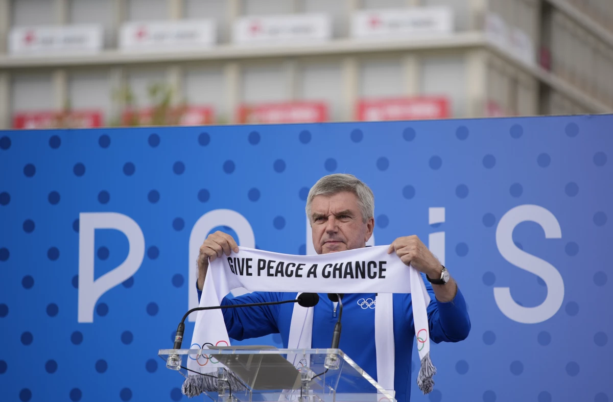 IOC President Thomas Bach holds a scarf during the inauguration of the Olympic Truce Wall in the Olympic Village at the 2024 Summer Olympics on Monday in Paris, France.
