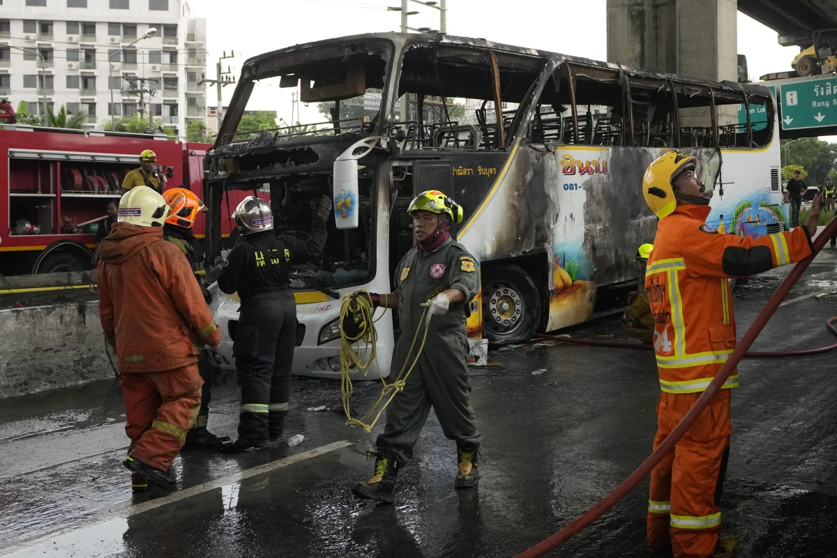 Rescuers work at the site of a bus that caught fire, carrying young students with their teachers, in suburban Bangkok on Tuesday.