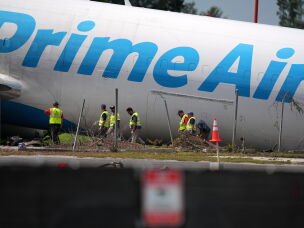 Workers inspect an Amazon cargo plane two days after it overshot a runway at Miami International Airport, Tuesday, Sept. 8, 2026, in Miami.