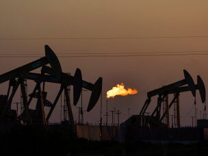 FILE - A flare burns off methane and other hydrocarbons as oil pumpjacks operate in the Permian Basin in Midland, Texas, on Oct. 12, 2021. (AP Photo/David Goldman, File)