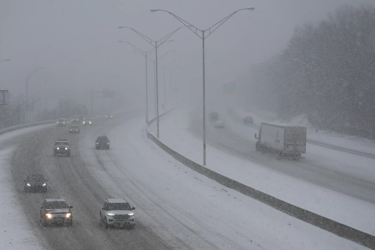 Vehicles drive along a highway during a winter storm, Sunday, Jan. 5, 2025, in Cincinnati.