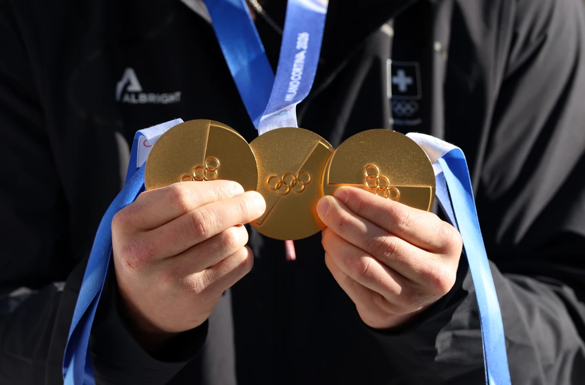 Triple Olympic Gold medalist Franjo von Allmen of Team Switzerland poses for a photo with his medals at the team hotel on Feb. 12 in Bormio, Italy.