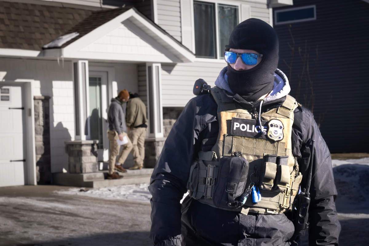 ICE agents look for someone at a home on Jan. 28 in Circle Pines, Minn. Protests continue around the Twin Cities area after the Trump administration sent thousands of immigration agents to the region to search for undocumented immigrants.