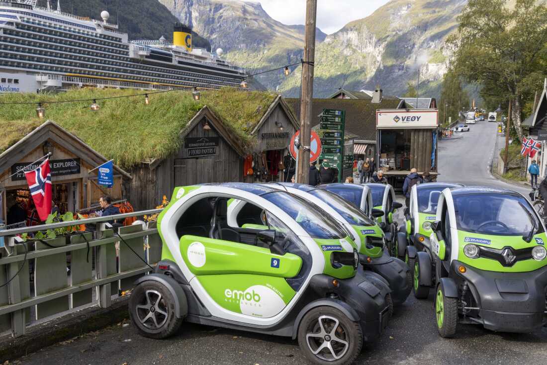 A group of electric vehicles are parked in Geiranger, Norway. The country has the highest rate of EV adoption in the world.