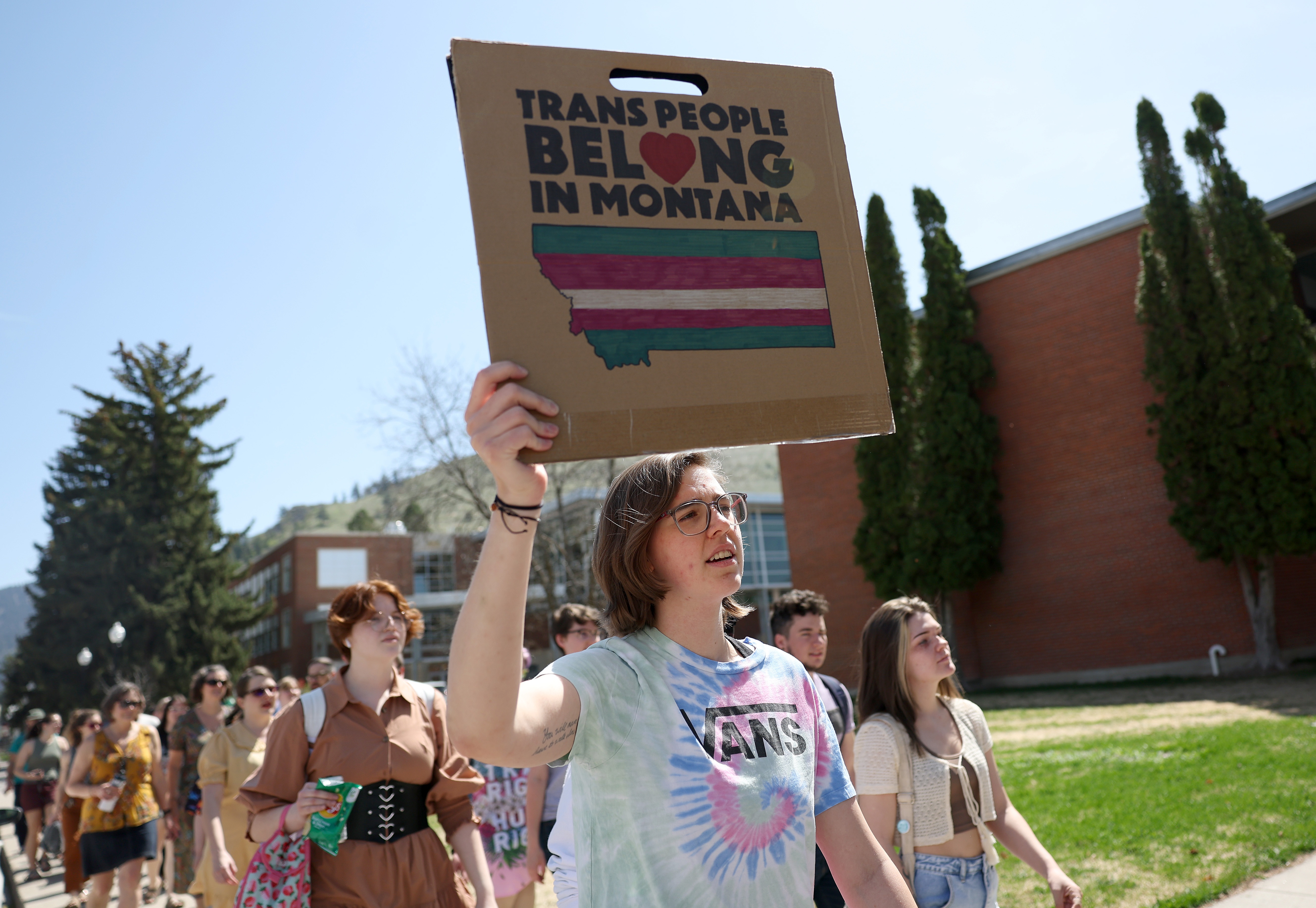 Transgender rights activists hold signs as they march through the University of Montana campus on May 03, 2023 in Missoula, Mont.