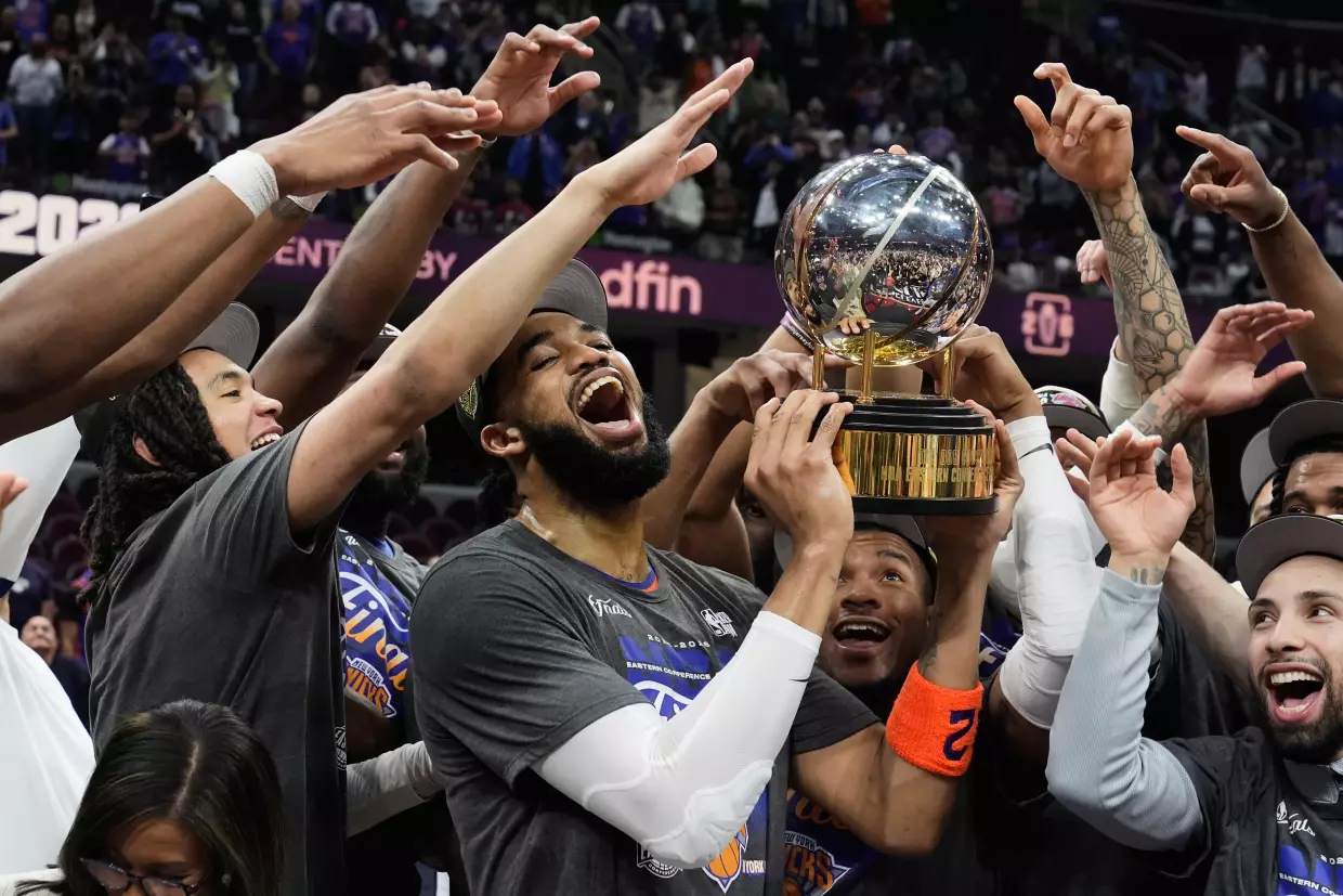 New York Knicks center Karl-Anthony Towns, center, and teammates celebrate after winning Game 4 in the Eastern Conference finals NBA basketball playoffs series against the Cleveland Cavaliers in Cleveland, Monday, May 25, 2026