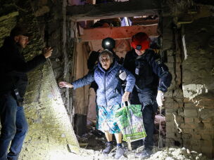 A policeman helps an elderly woman to walk out from a residential building damaged by a Russian airstrike in Zaporizhzhia, Ukraine, Saturday, Oct. 17, 2026.