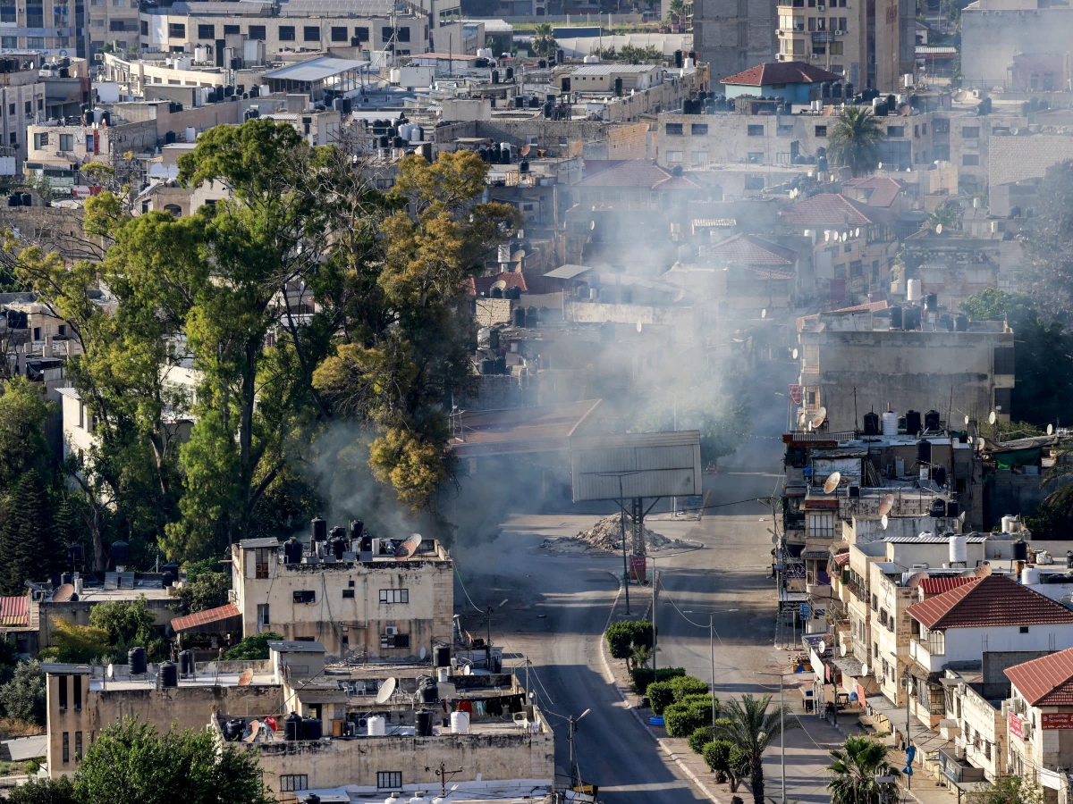 A cloud of smoke billows during an Israeli army raid in Jenin in the occupied West Bank on June 6. The Israeli military said it was investigating an incident in which a wounded Palestinian man was strapped to an Israeli military jeep while forces carried out 'counterterrorism operations' in Jenin on Saturday.