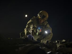 Oleksiy Yukov examines the body of a Russian soldier he collected on the frontline in the Sloviansk region of Ukraine in October 2023.