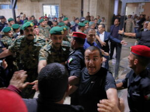 Soldiers and security officers hold back residents outside Prince Ali Military Hospital during King Abdullah II's visit to people wounded when gunmen opened fire during a funeral at a Greek Orthodox church hours earlier, in Karak, Jordan on Friday.