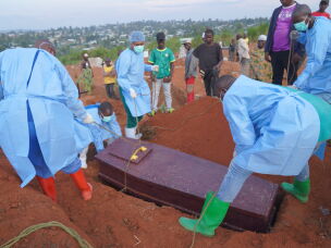 People dressed in protective gear lower into a grave the coffin containing the remains of 6-year-old Baudjo Baraka Jules, who died of Ebola, in Bunia, Ituri province, eastern Congo, Tuesday, Aug. 18, 2026.