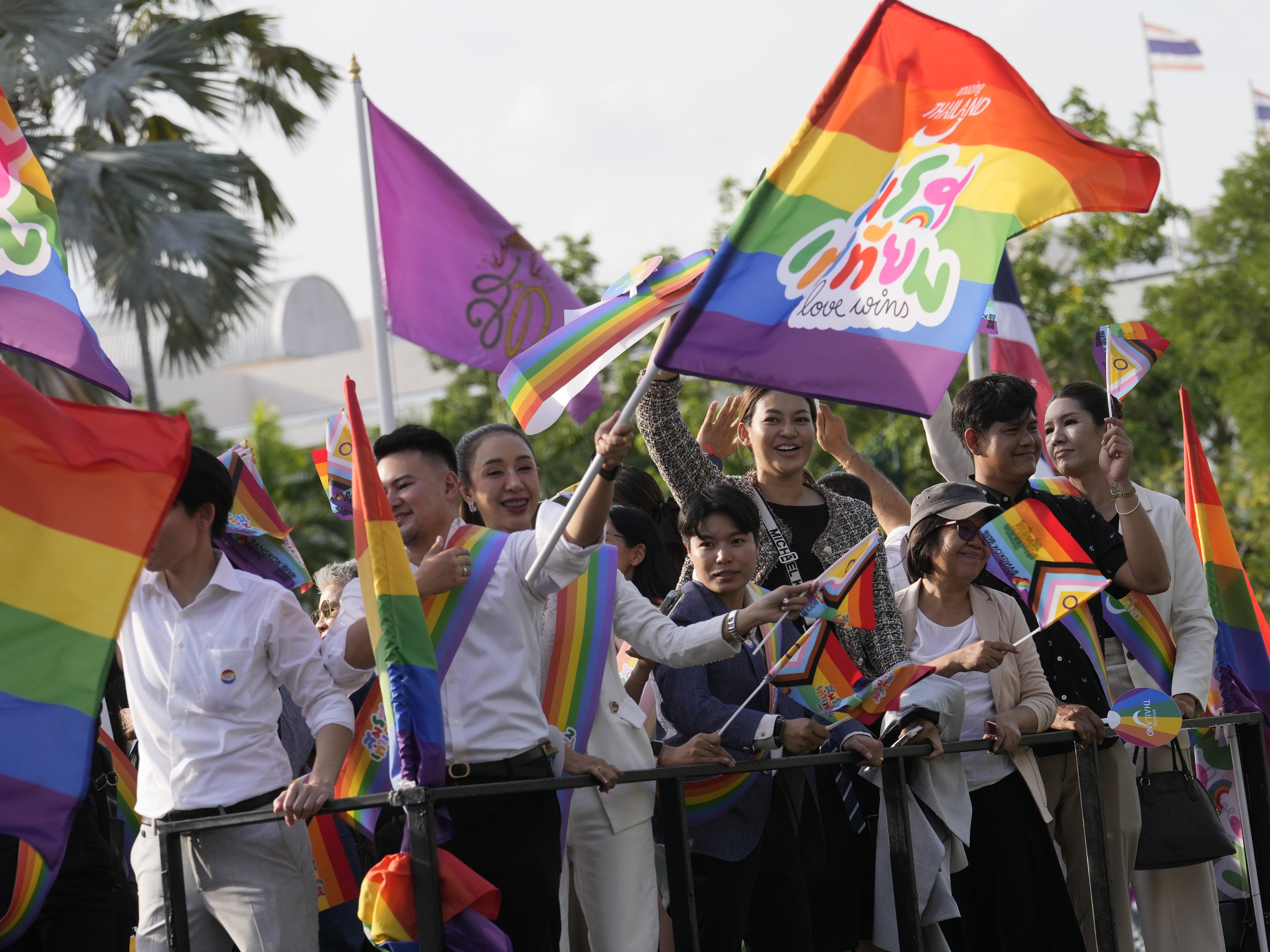 Participants wave flags celebrating marriage equality at the government house in Bangkok, Thailand, Tuesday. Thailand's Senate voted overwhelmingly to approve a marriage equality bill. (AP)