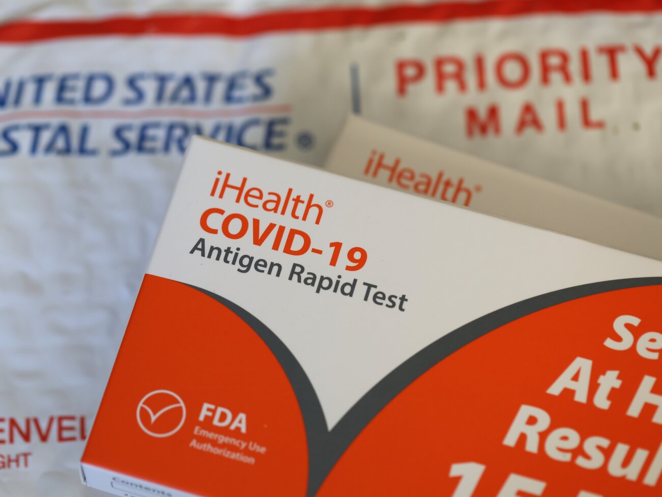 SAN ANSELMO, CALIFORNIA - FEBRUARY 04: In this photo illustration, free iHealth COVID-19 antigen rapid tests from the federal government sit on a U.S. Postal Service envelope after being delivered on February 04, 2022 in San Anselmo, California. The Biden administration has secured one billion at home COVID-19 tests and will deliver four per household for free to anyone who requests them. The tests can be ordered on the U.S. Postal Service website and will arrive 7-14 days after. (Photo Illustration by Justin Sullivan/Getty Images)