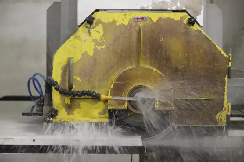 A computer operated wet saw cuts though an imported quartz slab in 2019.