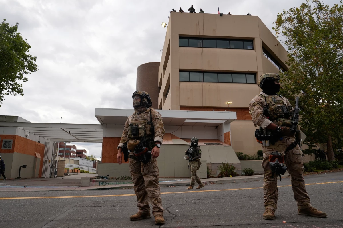 Customs and Border Protection agents stand outside an Immigration and Customs Enforcement facility in Portland, Ore., on Oct. 4.