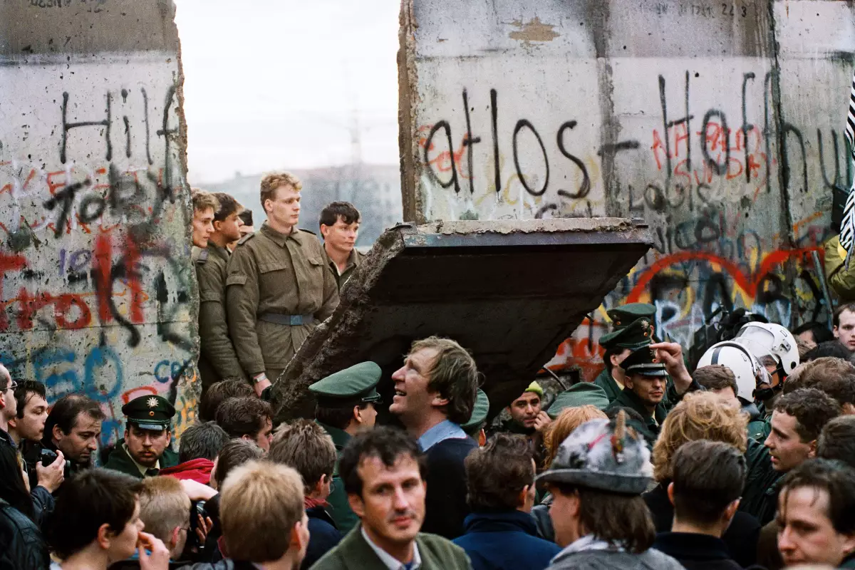 West Berliners crowd in front of the Berlin Wall early on Nov. 11, 1989, as they watch East German border guards demolish a section of the wall to open a new crossing point between East and West Berlin near the Potsdamer Platz public square.