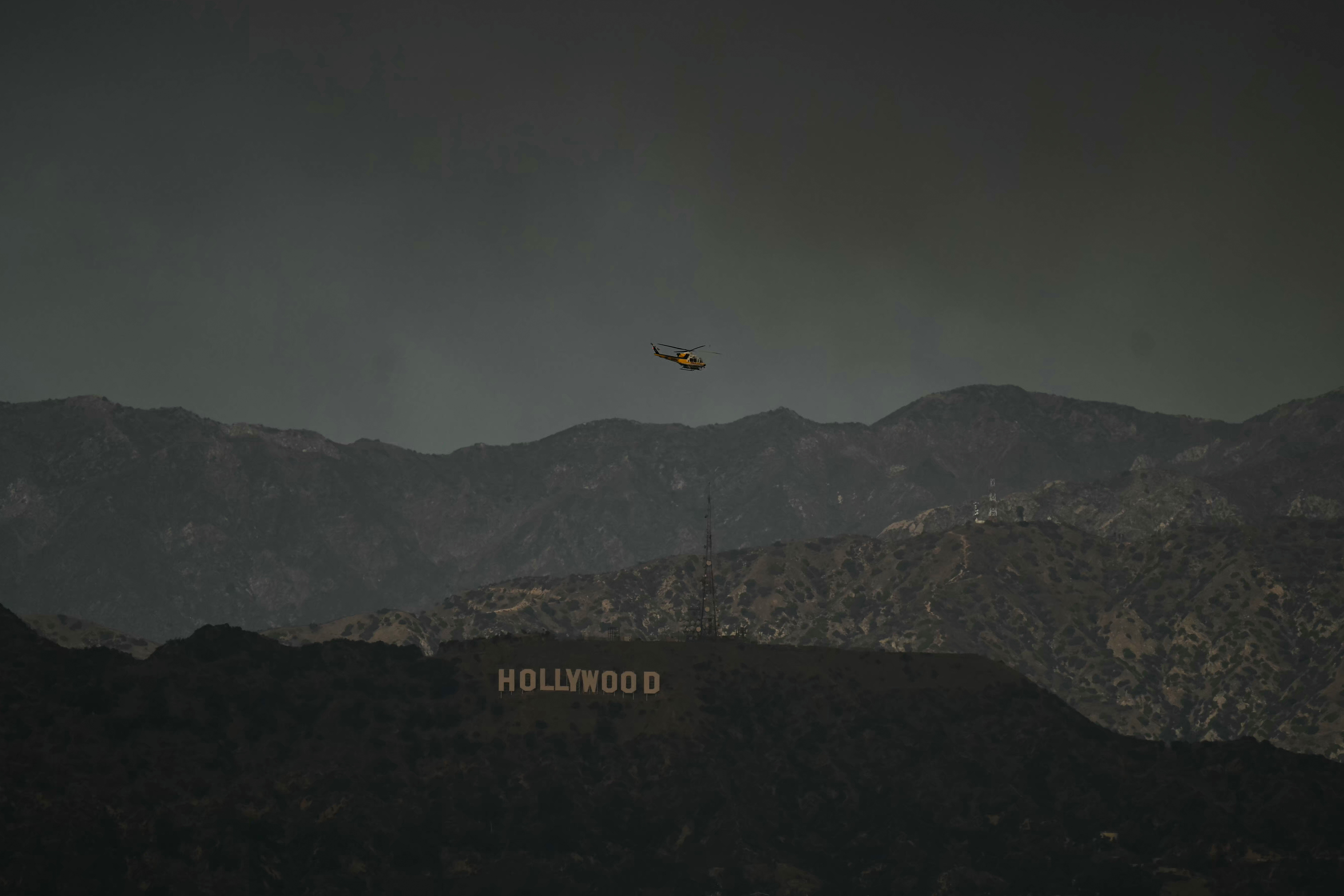 A firefighting helicopter flies above the Hollywood sign on Wednesday, Jan. 8.