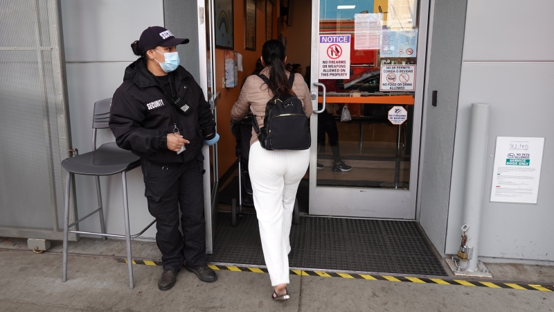 A security guard stands in front of the St. John’s Community Health clinic in South Los Angeles.