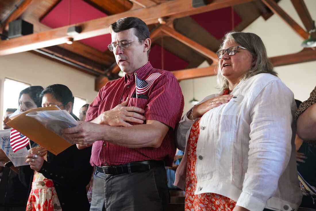 People say the Pledge of Allegiance as part of receiving their citizenship at a Nationalization Ceremony hosted by the Jimmy Carter National Historical Park on Oct. 1, 2024 in Plains, Georgia. The Justice Department is directing its attorneys to prioritize denaturalization in cases involving naturalized citizens who commit certain crimes, according to a June memo.