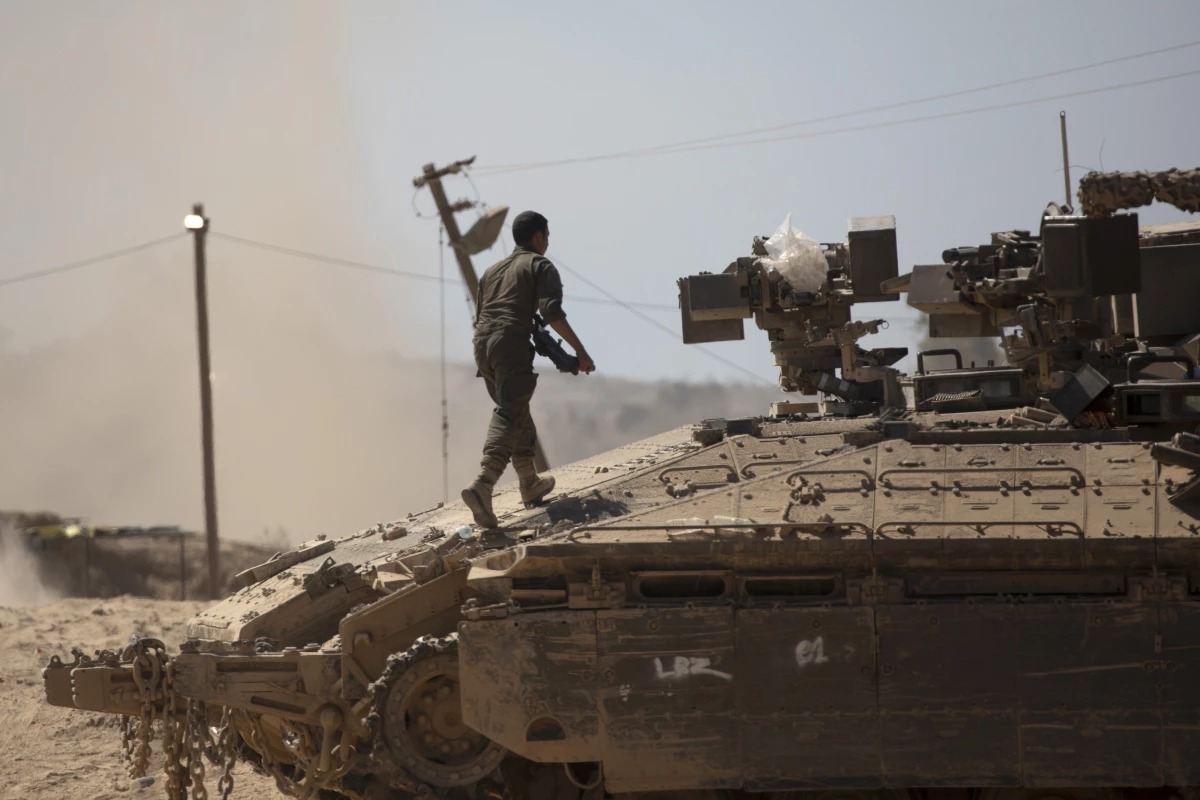 An Israeli soldier walks on a tank near the border of the Gaza Strip in southern Israel on Aug. 21.