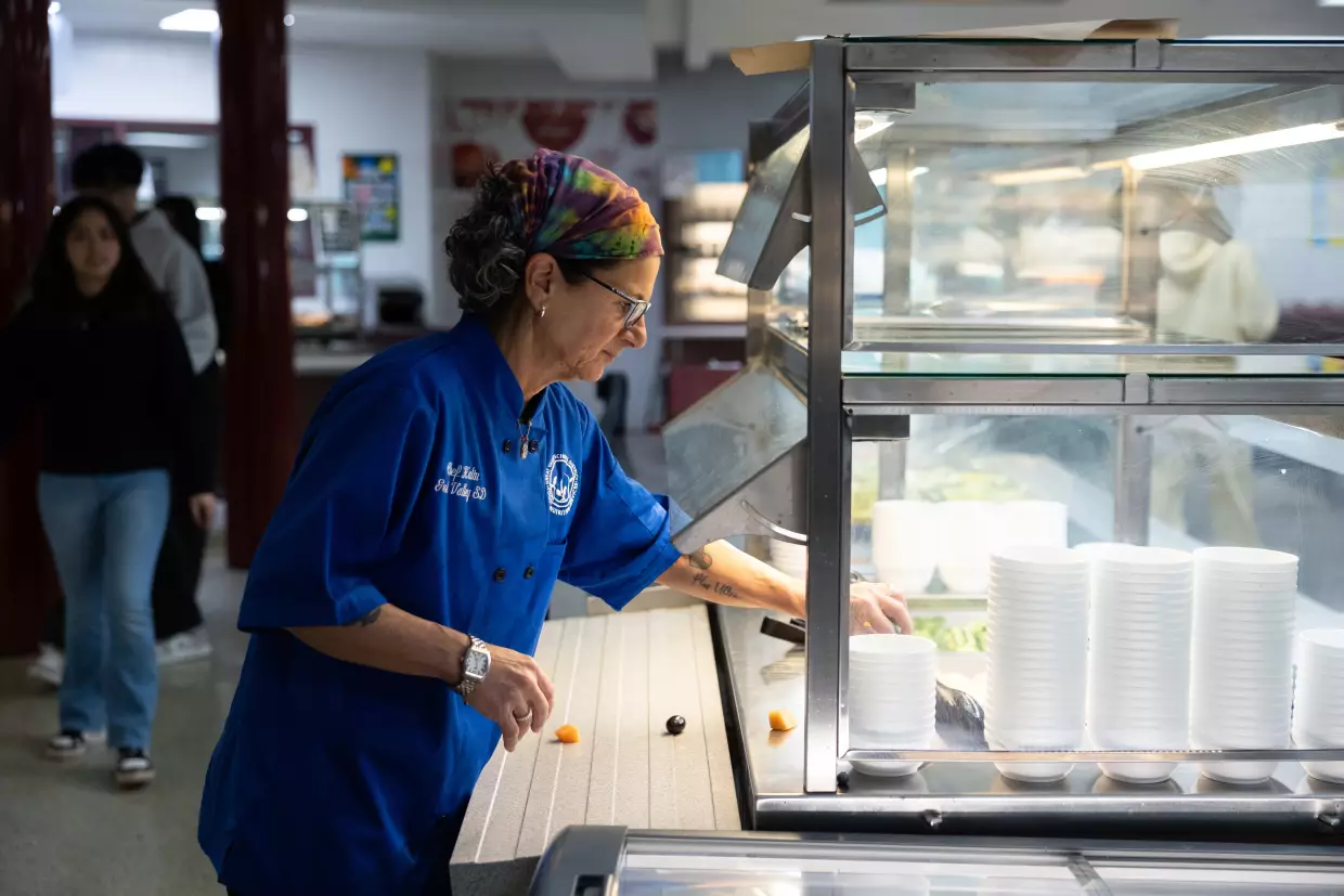 Great Valley School District culinary coordinator Jenifer Halin cleans up the salad bar in the cafeteria at Great Valley High School in Malvern, Pennsylvania.