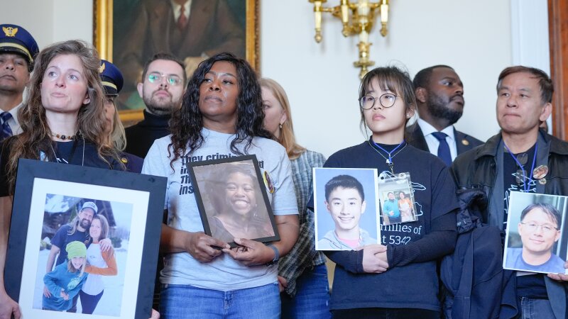 Family members of people who were killed in the midair collision near Ronald Reagan Washington National Airport hold portraits of their loved ones as they stand and listen during a news conference ahead of a vote on an aviation safety bill on Capitol Hill.