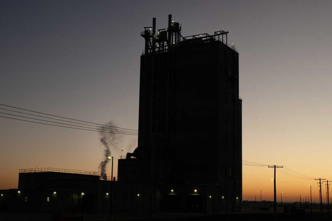 A factory plant billows smoke in the early hours of the morning, Saturday, Dec. 21, 2024, in Fremont, Nebraska. Immigrant workers, primarily from El Salvador and Guatemala, have been moving to Nebraska, where there are multiple factories and jobs. State-wide, Nebraska is experiencing labor shortages, publicly declaring themselves as welcoming to immigrants. The state voted in its majority for President Trump, who campaigned on plans of mass deportation. (Lexi Parra for NPR)