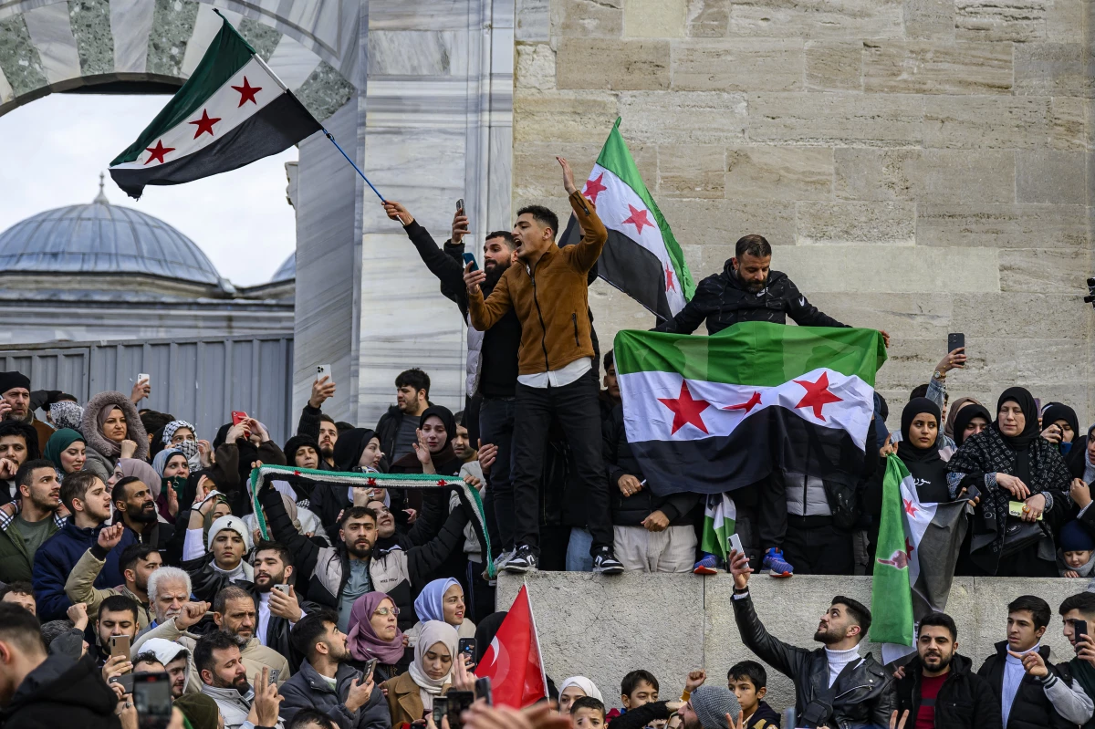 Syrian residents in Turkey wave Syrian opposition flags as they celebrate the President Bashar al-Assad's rule in Syria after rebel fighters took control of Damascus overnight, at the Fatih Mosque, in Istanbul, on Sunday.